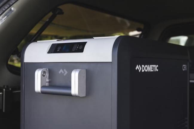 Dometic portable fridge-freezer positioned in the back of a campervan.