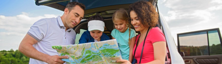 cheerful family searching their destination in the USA using a map