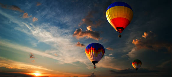 colorful hot air balloon is flying at sunrise