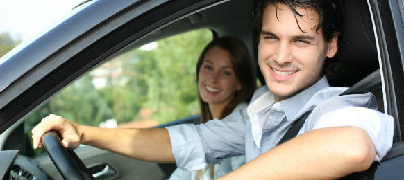 couple smiling inside their rental car