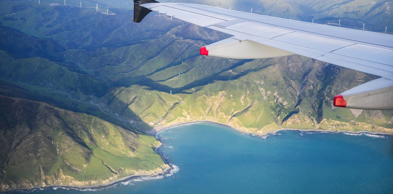 Aerial view of mountains and bays from an airplane flying towards Wellington Airport