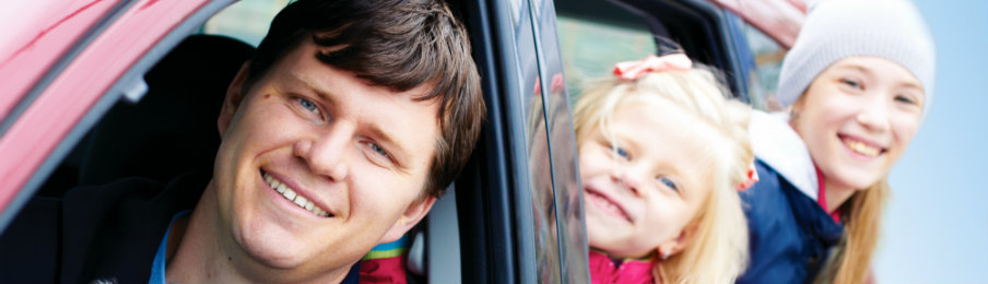 happy family inside a red car