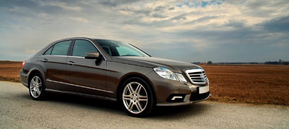 front view of a luxury car on country road with dramatic sky