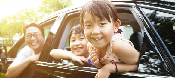 happy children with their father inside the hire car