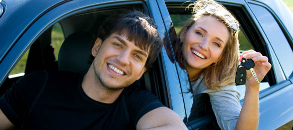 happy couple inside the car rental while holding keys