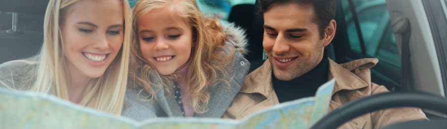happy family in the car holding a map