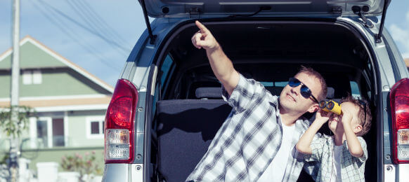 happy father and son getting ready for roadtrip in a car hire