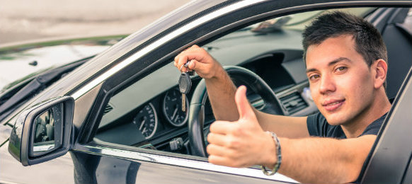 male driver making a thumbs up sign inside his car