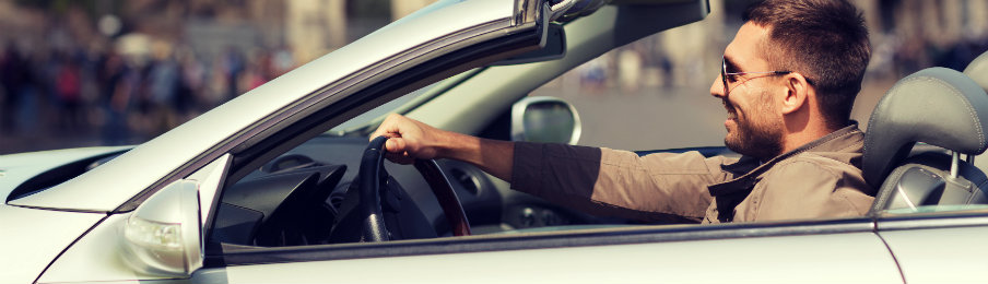 happy man driving car rental in the city