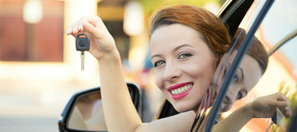 foreign traveler showing the key to her car hire