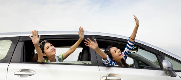 happy girls in their car rental and enjoying vacation