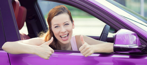 happy woman in a pink car