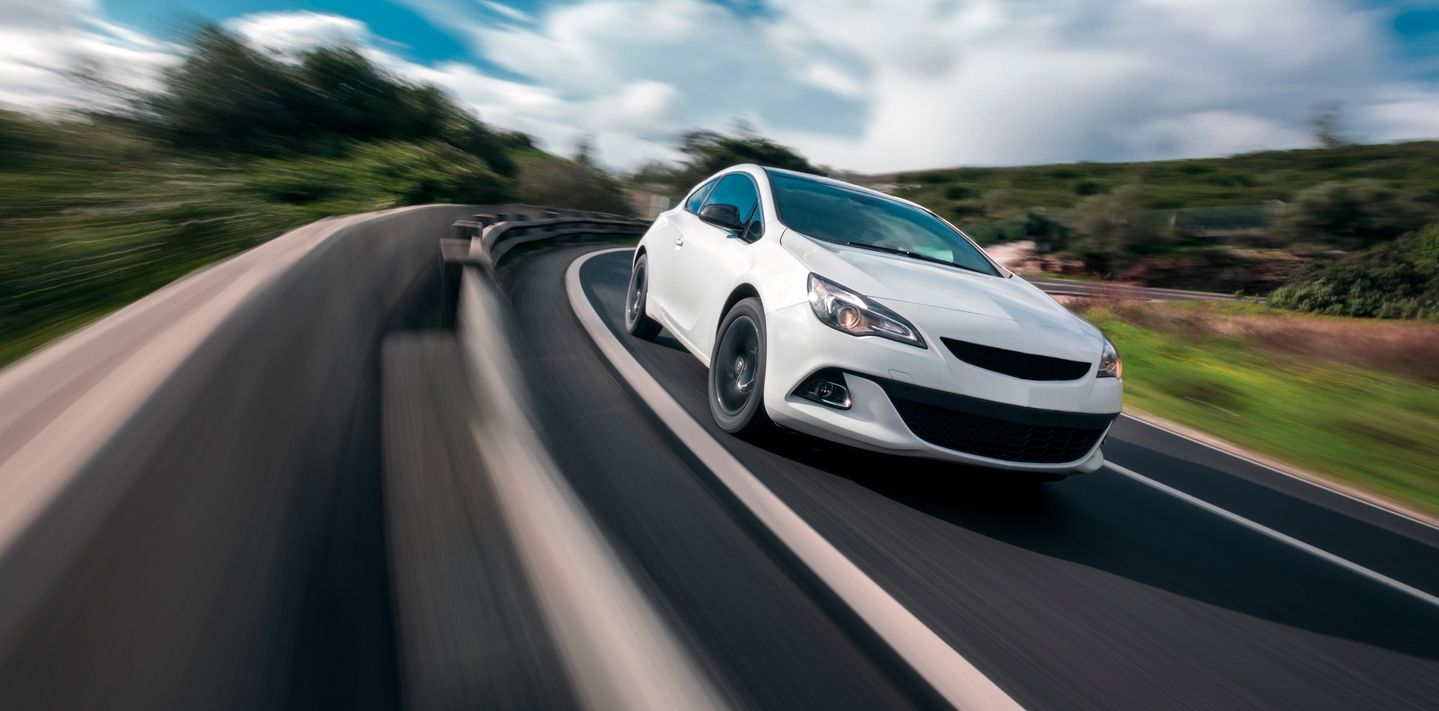 A white car cornering at speed.
