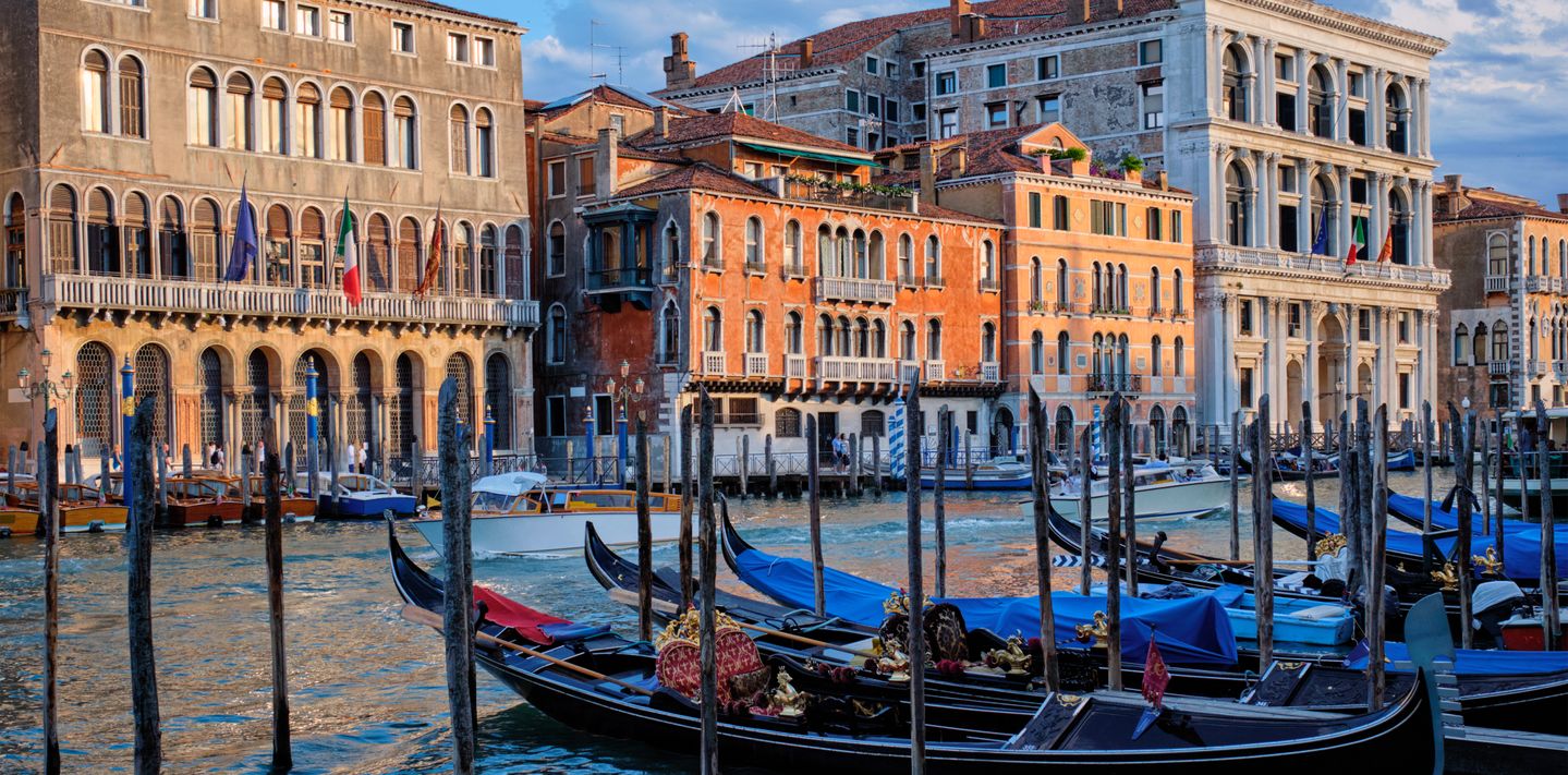 Grand Canal with boats and gondolas at sunset, Venice, Italy.