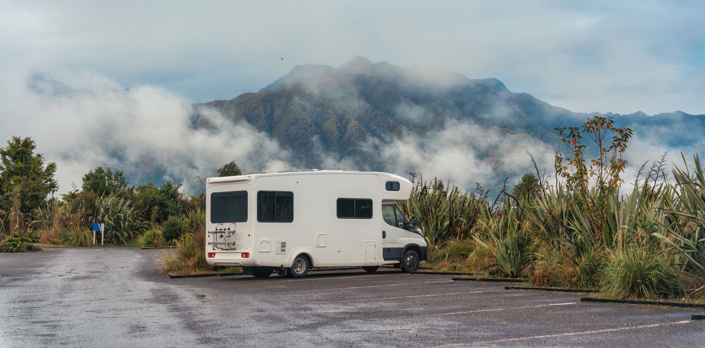A campervan parked in a forest in New Zealand.