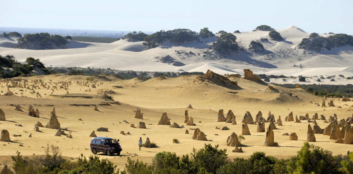 A van parked next to the Pinnacles at Nambung National Park.