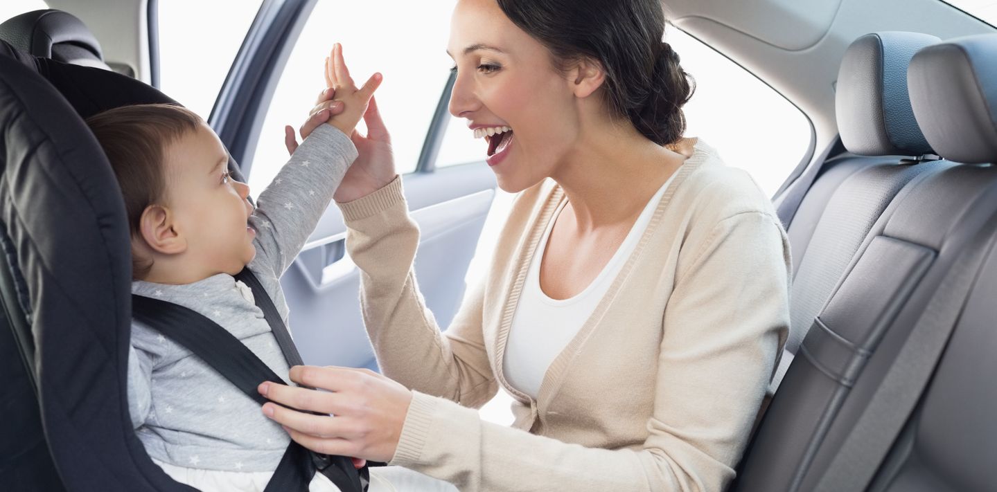 Strapping a child into a baby seat.