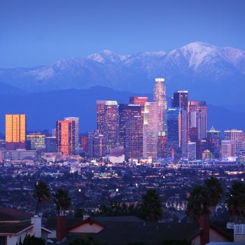 los angeles skyline over snowy mountains