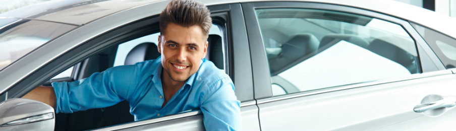 young male professional driving a rental car