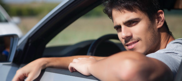 A handsome man smiling while in the car