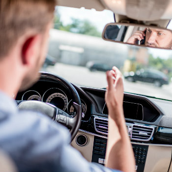 man using his phone while driving
