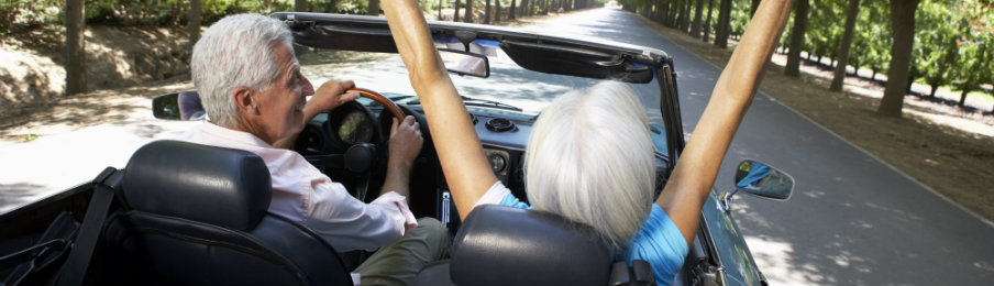 senior couple riding a car rental