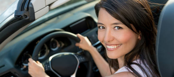 smiling pretty asian young woman driving a car