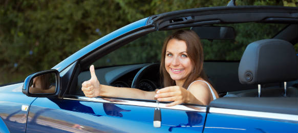 smiling caucasian woman key in a her blue car rental
