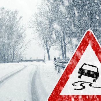 snowfall country road with warning sign