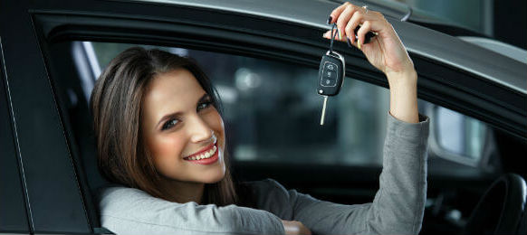 woman driver holding keys while siting in her car hire