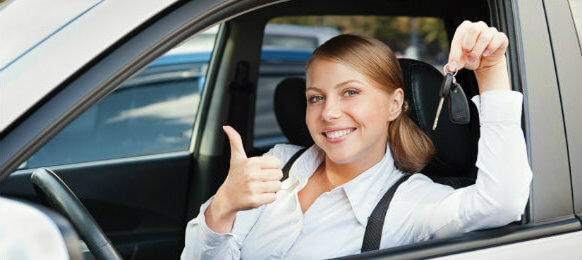 woman holding a key and showing thumbs up