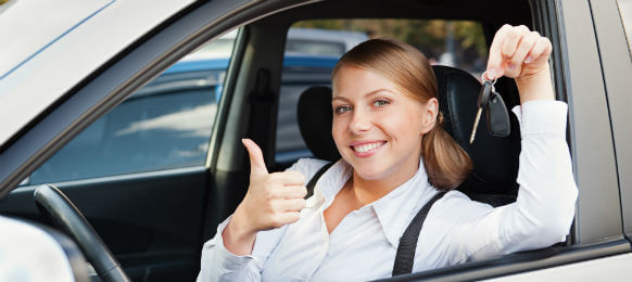 woman in a car hire holding a key