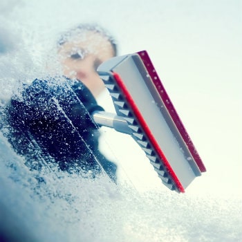 woman scraping ice from windshield