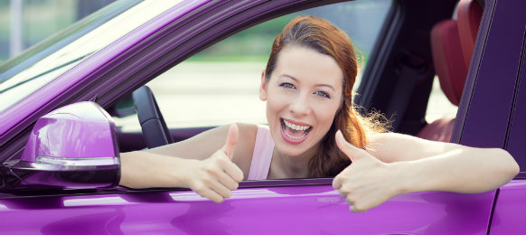 Lady giving a two thumbs up while in the car