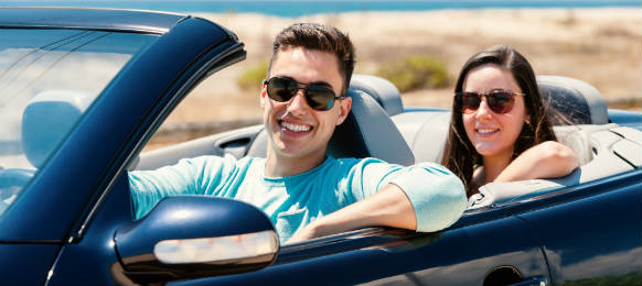young couple in their convertable car rental looking fine