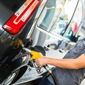 Young man filling up his hire car at the gas station
