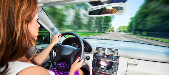 young woman driving her car rental in a fast motion effect