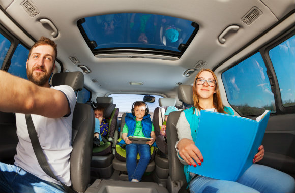 family on a road trip and busy children playing gadgets