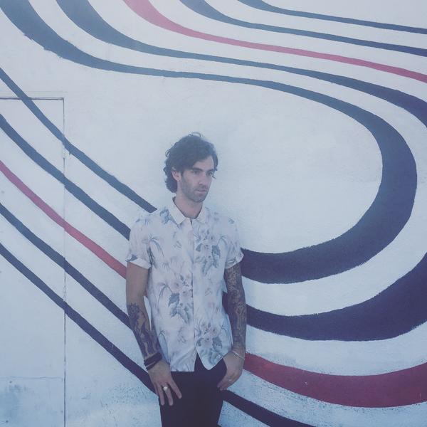 Zac Barnett in front of the Elliott Smith’s "Figure 8" album cover wall in LA.