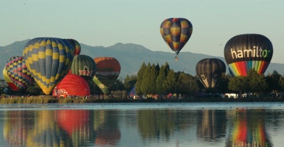 Balloons rising over water
