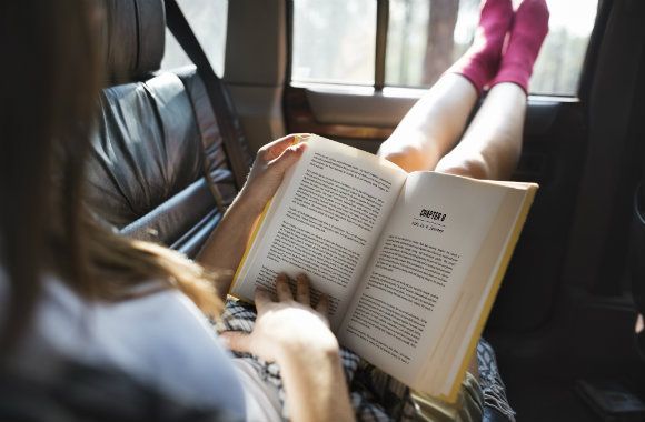 girl reading a book in a car