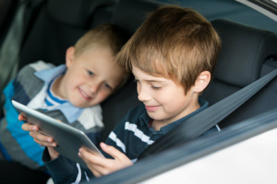 kids-playing-gadget-while-in-a-road-trip-dp