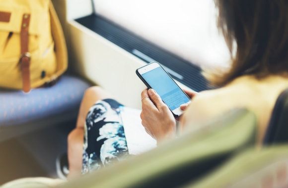 Woman using mobile phone to book a car rental