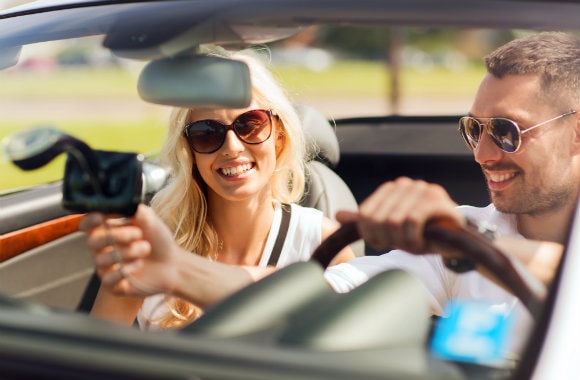 cheerful couple checking GPS while on a road trip