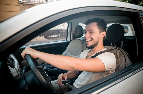 man driving a compact car in the city
