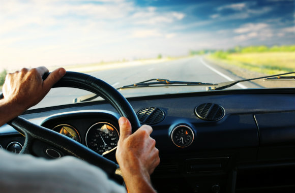 Man driving a car while on the road